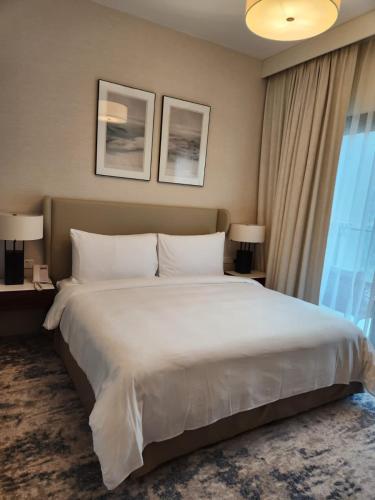 富查伊拉Address Beach Resort Fujairah - 2 bedroom apartment的一张大白色床,位于酒店带窗户的房间内