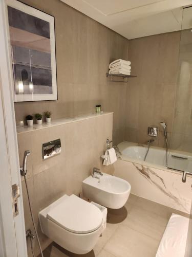 富查伊拉Address Beach Resort Fujairah - 2 bedroom apartment的浴室配有卫生间、盥洗盆和浴缸。