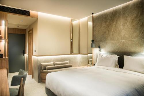赫索尼索斯KING MINOS RETREAT Resort & Spa的酒店客房带一张大床和一把椅子