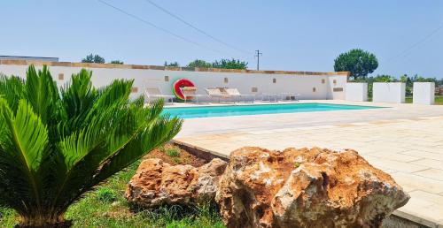 蒂贾诺Villa Marzoni con Piscina Privata by HDSalento的一座棕榈树游泳池和一座建筑