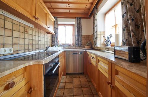 萨尔巴赫FIVE SEASONS - Hideaway Saalbach的厨房配有木制橱柜、水槽和窗户。