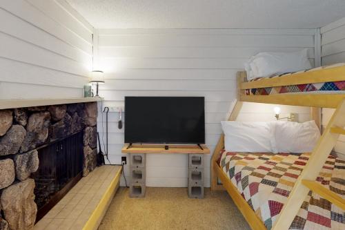 桑德波因特Slope-Walk Condo的一间卧室配有电视、一张床和双层床。