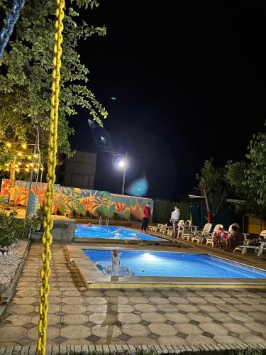 乔尔蓬阿塔Гостевой дом Асель的夜间游泳池,周围的人在泳池周围