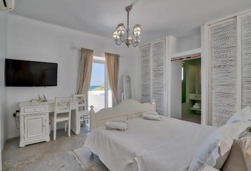安迪帕罗斯岛Villa Yialos的一间白色卧室,配有床、书桌和电视