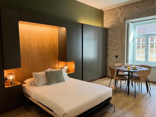 波尔图Oca Ribeira do Porto AT的酒店客房配有一张床铺和一张桌子。