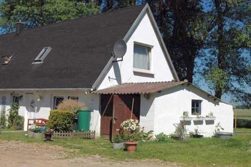 乌曼茨Ruegen_Fewo 69的一间黑色屋顶的白色小房子