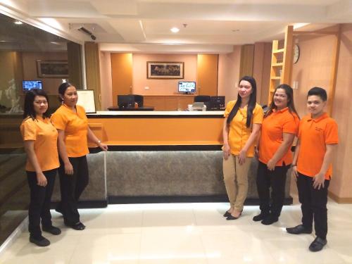 马尼拉帕塞石屋酒店的一群身穿橙色衬衫的人站在大堂