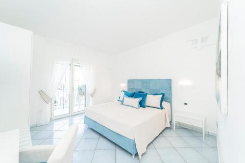 米诺利Residenza Sant'Angelo - Art Apartment的白色卧室配有蓝色枕头的床