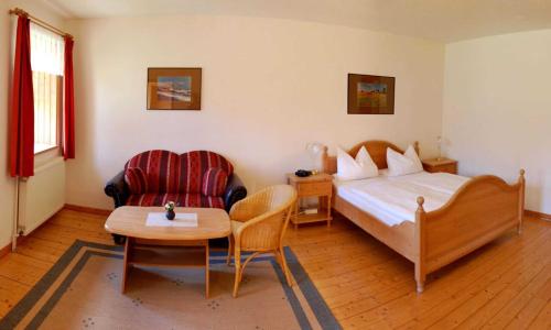 吕根岛上的维克Ruegen Fewo 106的卧室配有1张床、1张桌子和1把椅子