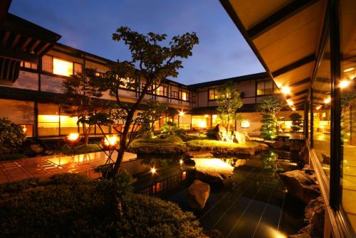 丰冈市大西屋水翔苑的一座建筑前有池塘的酒店