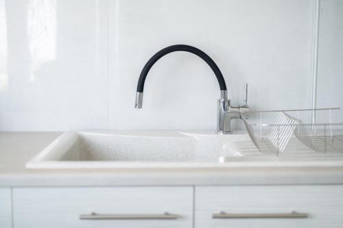 凯法洛斯Saint Nicholas Houses的白色厨房内带水龙头的盥洗盆