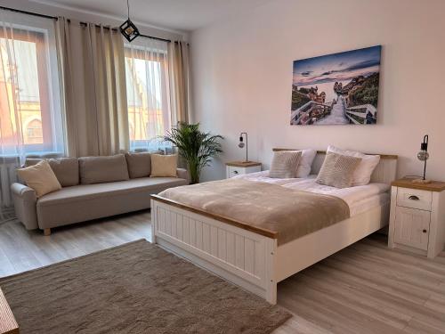 斯维诺乌伊希切Apartamenty Przy Deptaku的一间卧室配有一张大床和一张沙发