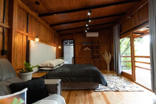 本图贡萨尔维斯Cabana Grafe的一间卧室配有一张床和一张沙发