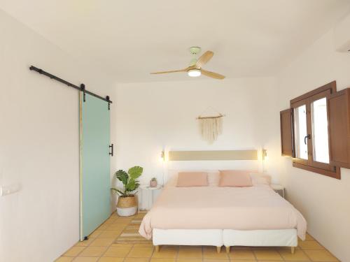 拉斯内格拉斯Casa A.Mar的卧室配有白色的床和吊扇