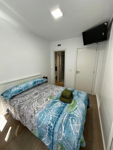 马德里Alojamiento Aguacate的一间卧室配有一张带蓝色棉被的床