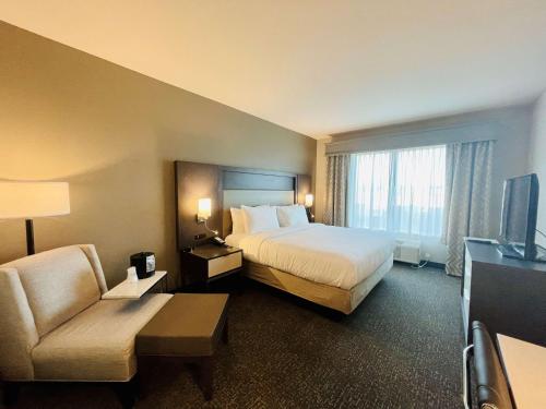 杰克逊Best Western Plus Executive Residency Jackson Northeast的酒店客房设有一张大床和一张沙发。