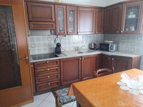 奥斯塔Casa vacanze Gianluca的厨房配有木制橱柜、水槽和桌子