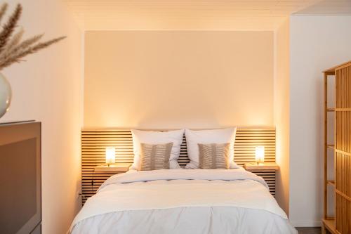 拜罗伊特Stilvolles Apartment in Bayreuther Fußgängerzone的一间卧室配有一张大床和两盏灯