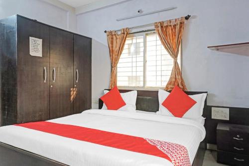 LohogaonOYO Flagship 87488 Hotel Green Breeze的一间卧室配有一张带红色枕头的大床