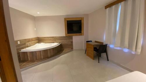 里约热内卢Verona Hotel的一间带桌椅的浴缸的浴室