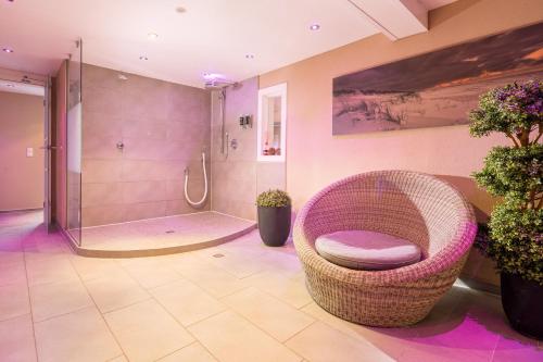 朗格奥克罗格诺德希酒店的一间带柳条椅和淋浴的浴室