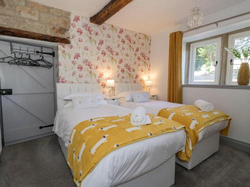 希普利Cunliffe House的卧室设有两张单人床,装饰有花卉壁纸