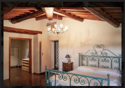 阿雷佐Casale di mamma Antonella的一间卧室配有蓝色的床和吊灯。