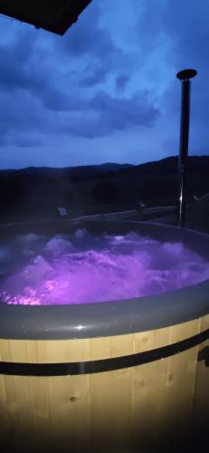 ManiowyGóralskie Domki na Podhalu - z jacuzzi的紫色的浴缸,紫色的天空