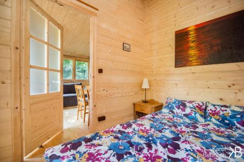 姆拉哥沃Mazurskisen的一间卧室设有一张床和木墙