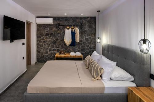 弗通Potamida Suites的一间卧室设有一张大床和石墙