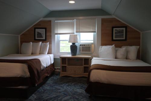 大洋城The Burgundy Inn Hotel and Apartments的酒店客房设有两张床和窗户。