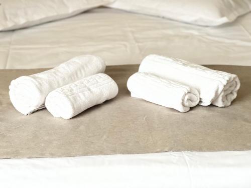 艾福雷诺德Casa Mario的两卷白色毛巾,坐在床上