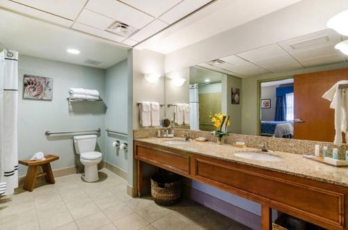 堪萨斯城Unity Hotel and Conference Ctr, Ascend Hotel Collection的浴室设有2个水槽、卫生间和镜子。