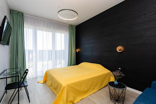 帕兰加2NIGHT in Šventoji的一间卧室设有黄色的床和窗户。
