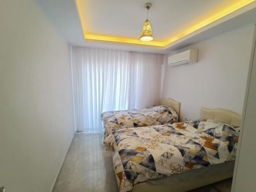 库萨达斯Flat For Rent At The City Center Of Kuşadası的一间卧室设有两张床和窗户。