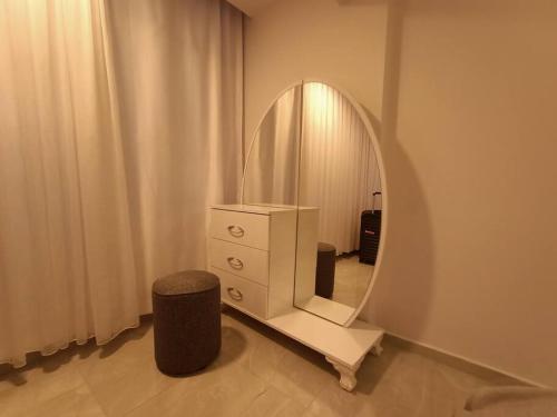 库萨达斯Flat For Rent At The City Center Of Kuşadası的白色梳妆台,配有镜子和凳子