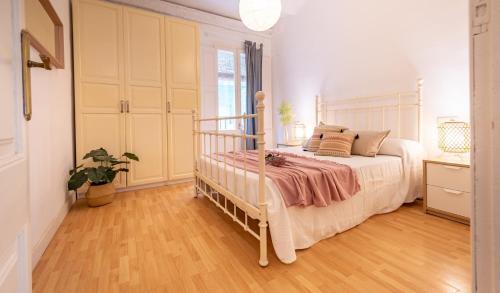 塔拉戈纳Acogedor apartamento en Serrallo的卧室配有白色的床,铺有木地板