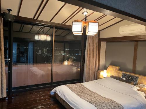大津FEEL LAKE　VIEW的一间卧室设有一张床和一个大型玻璃窗