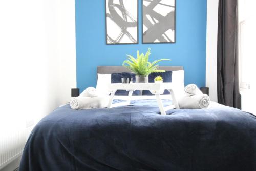 伍尔弗汉普顿Amazing - 1BDR - Free Street Parking的蓝色卧室配有一张带白色桌子的床