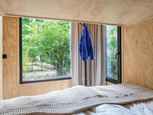 宁斯佩特TED Tiny House的一间卧室设有一张床和一个大窗户