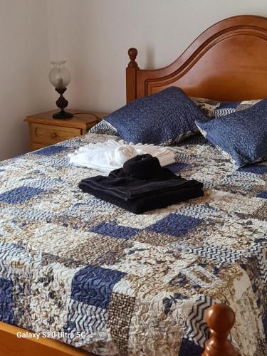 Lajes das FloresAL Luso Brasileiro的床上有蓝色和白色的被子