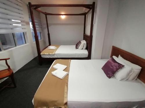 龙运Mi Hotel 2 Dungun的一间设有两张床、一张桌子和一把椅子的房间
