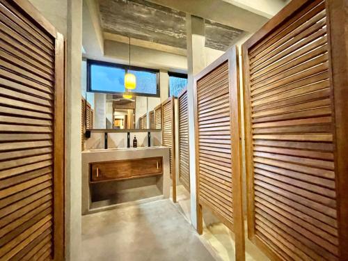 埃斯孔迪多港Nectar Hotel, Cafe, Cowork - Adults Only的浴室设有木墙、水槽和镜子