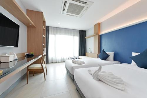曼谷VST Punnawithi - SHA Certified的一间酒店客房,设有两张床和电视