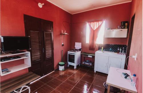 巴拉格兰德Sobrado do Eduardo的一间厨房,配有红色的墙壁、一台电视和一张桌子