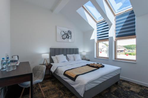 尼彻兹Apartamenty Klifowa 7的卧室配有一张床、一张书桌和窗户。