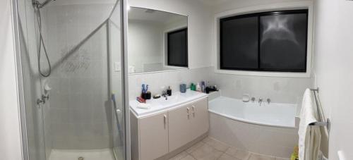 Taylors LakesWatergardens Lodge的带淋浴、盥洗盆和镜子的浴室