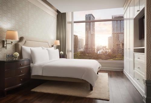 曼谷曼谷东临俪舍的一间卧室设有一张大床和一个大窗户