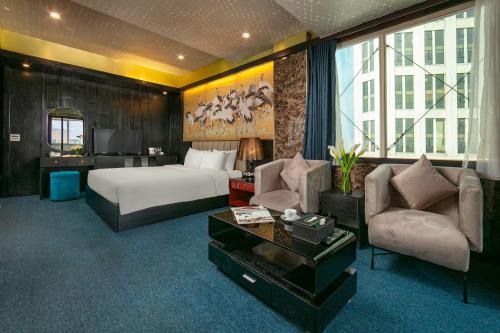 河内Ja Cosmo Hotel and Spa的酒店客房,配有床、沙发和椅子