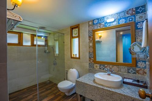 奎隆Fragrant Nature Backwater Resort & Ayurveda Spa Kollam的一间带水槽、卫生间和镜子的浴室